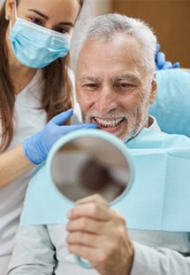 patient smiling while looking in dental mirror 