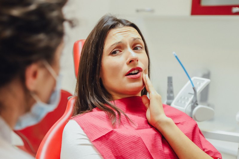 A woman with a toothache seeing her dentist for help